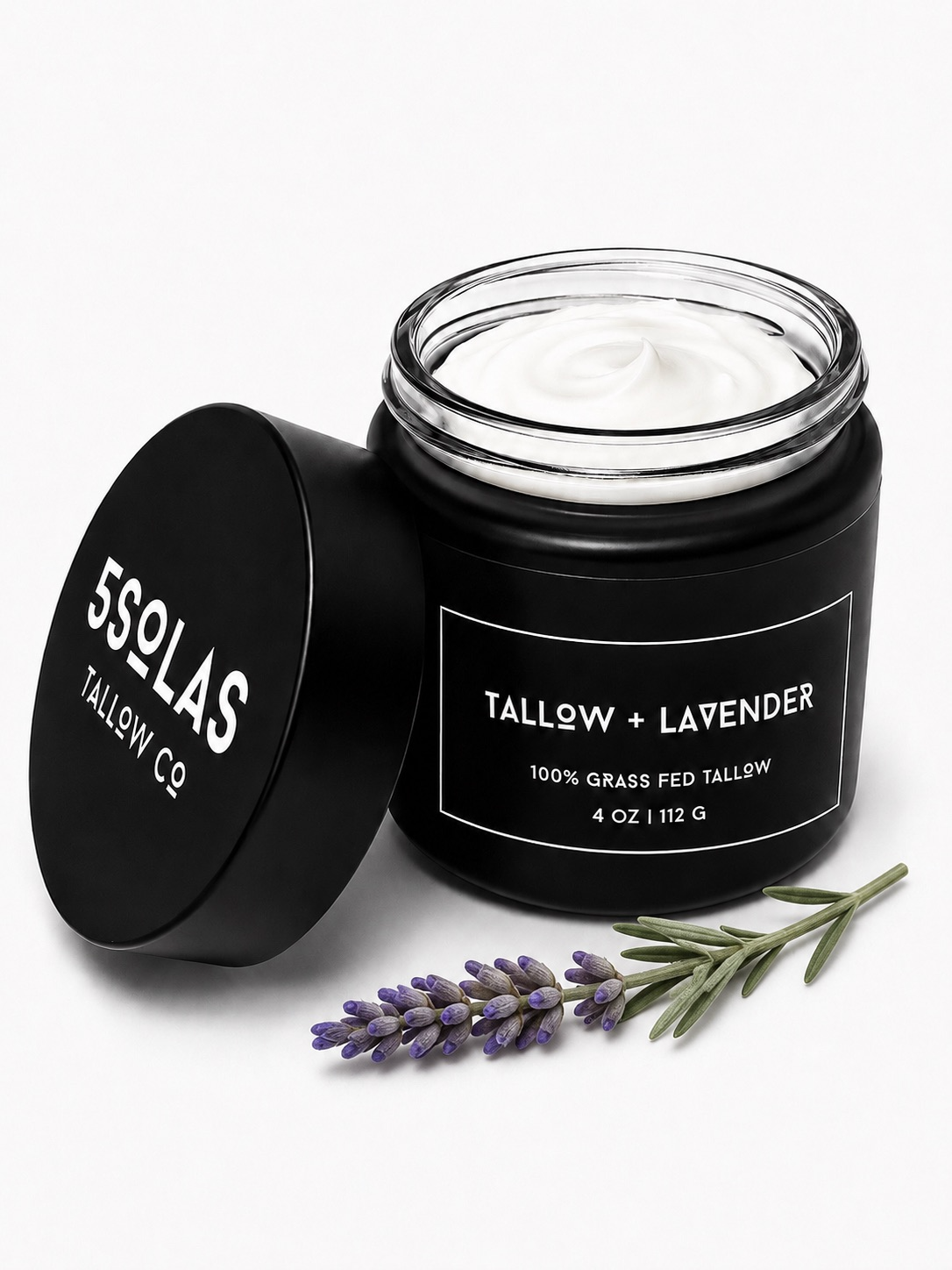 Open jar of 5Solas Tallow Co. grass‑fed tallow skin balm in the lavender blend, shown with natural ingredients around the container.