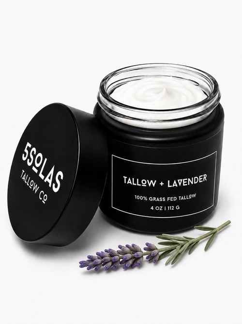 Open jar of 5Solas Tallow Co. grass‑fed tallow skin balm in the lavender blend, shown with natural ingredients around the container.