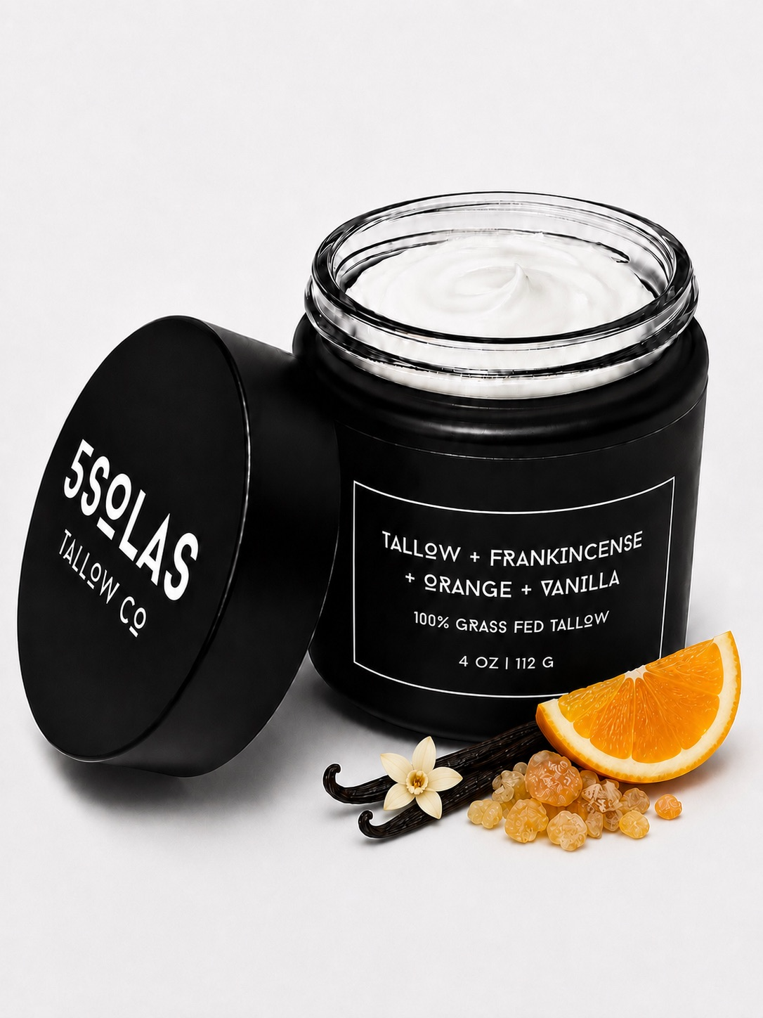 Open jar of 5Solas Tallow Co. grass‑fed tallow skin balm in the frankincense + orange + vanilla blend, shown with natural ingredients around the container.
