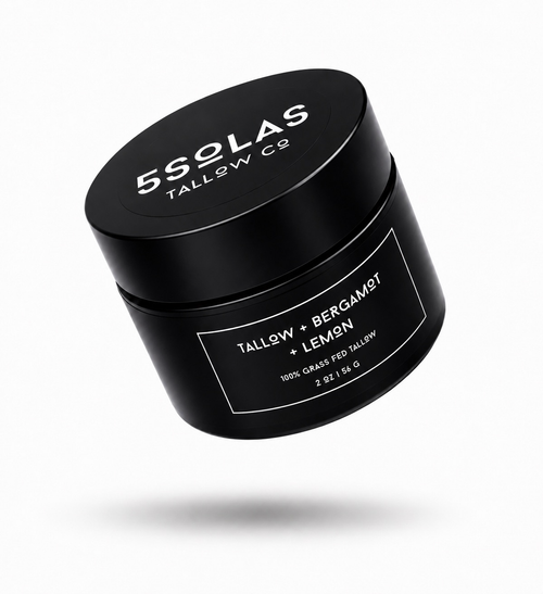 A black cylindrical cosmetic jar with a matching lid, floating at an angle on a light gray background. The lid and label are printed with white text reading '5SOLAS TALLOW CO' and 'TALLOW + BERGAMOT + LEMON'.