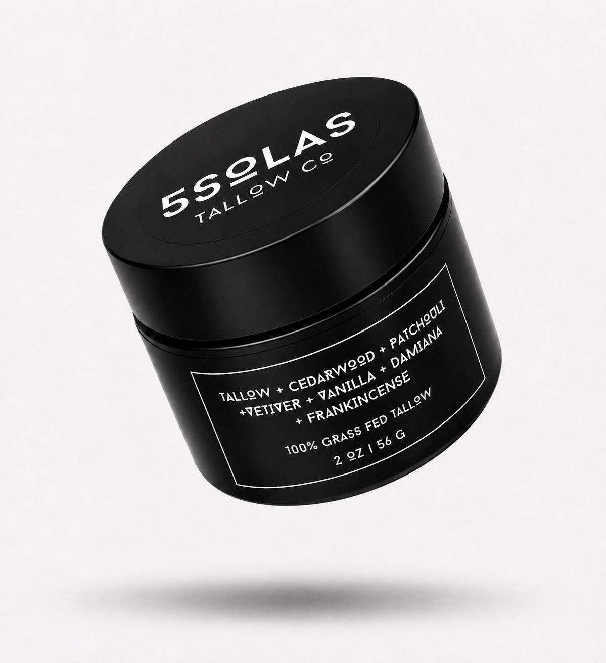 A black cylindrical cosmetic jar with a matching lid, floating at an angle on a light gray background. The lid and label are printed with white text reading '5SOLAS TALLOW CO' and 'TALLOW + CEDARWOOD + PATCHOULI + VETIVER + VANILA + DAMIANA + FRANKINCENSE'.